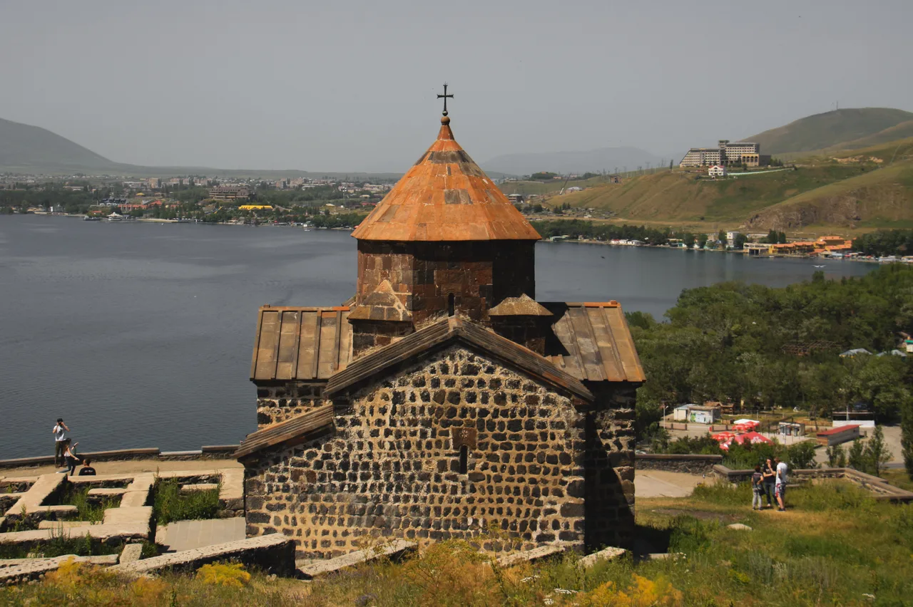 The Sevanavank monastery on its green peninsula above the deep-blue water of Lake Sevan under a summer sky