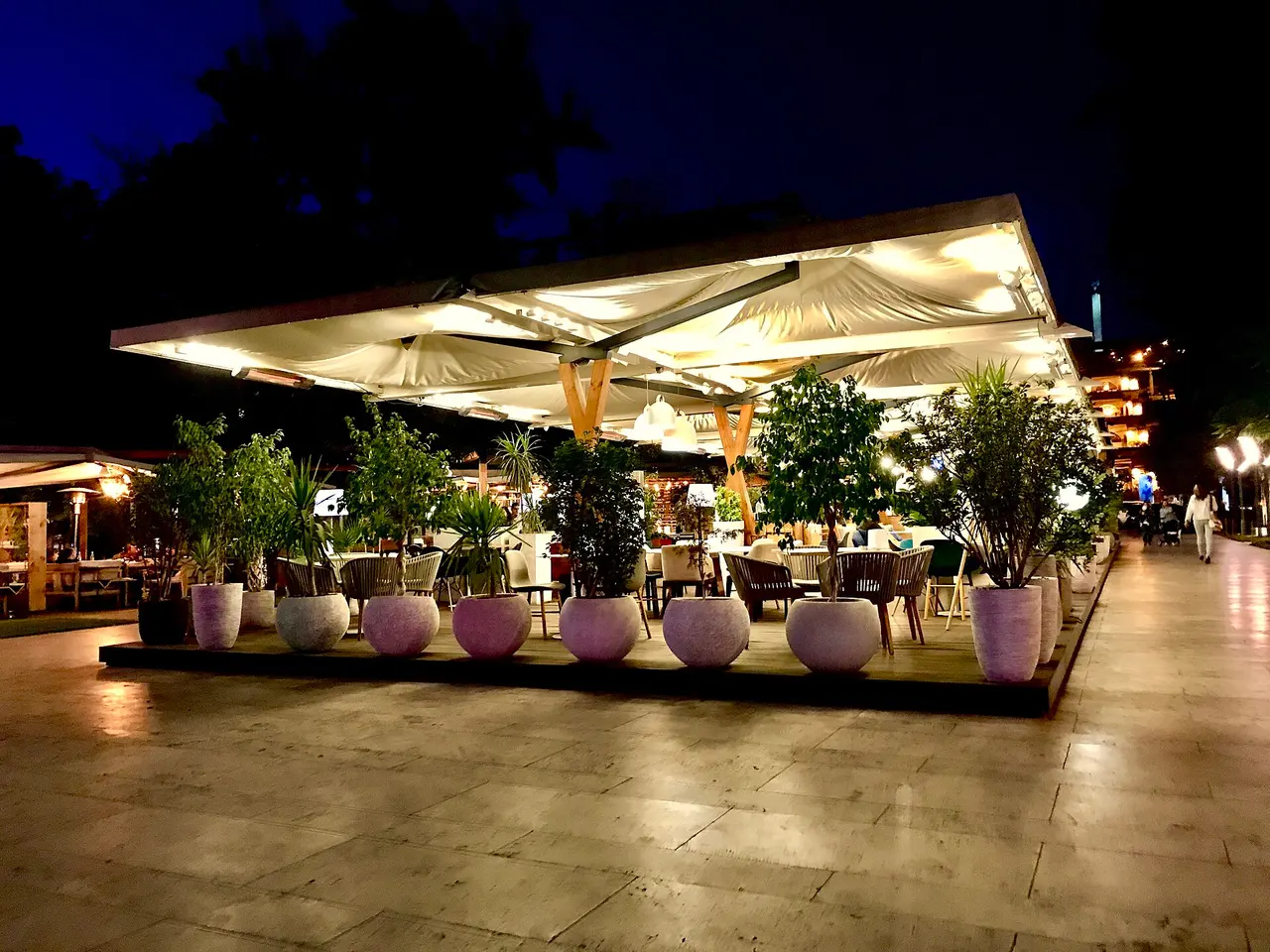 People sitting out at an open-air cafe on a leafy Yerevan street in summer