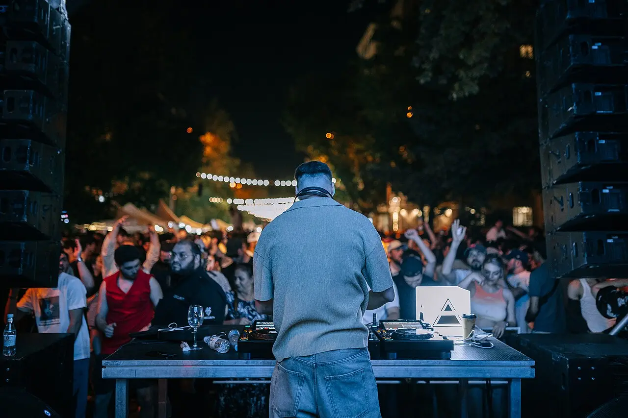 A DJ stage and crowd on a closed Yerevan street at night during the wine festival